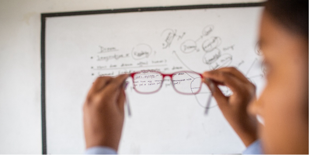 Student looks at the blackboard through glasses